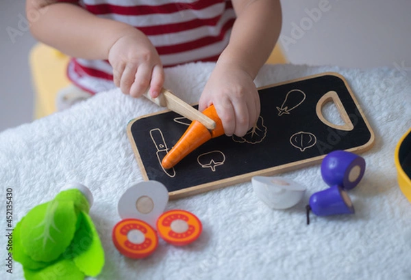 Fototapeta Baby play with developmental toys that can help fine motor skills, learn through play concept.