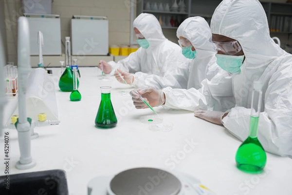 Fototapeta Chemists testing green liquid in petri dishes