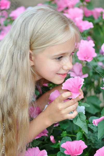 Obraz Красивая девушка нюхает цветы лаватера (Lavatera)