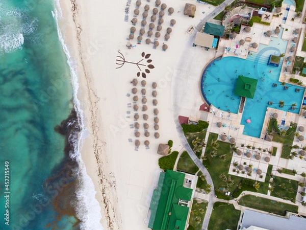 Fototapeta A resort town with a developed infrastructure on the ocean shore .. White sandy beach. The water near the shore is polluted with debris and algae. Environmental protection.