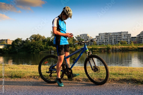 Fototapeta Hobbistyczna jazda na rowerze. Rowerzysta przegląda mapę w smartfonie