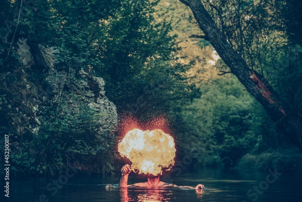 Fototapeta Man in a river blowing fire