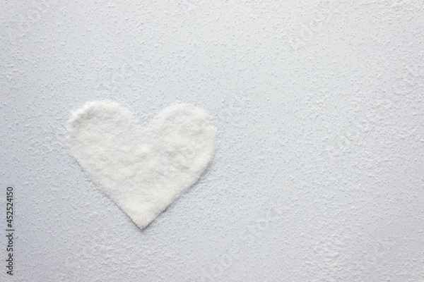 Fototapeta White sugar crystals in the shape of a heart. Copy space