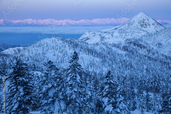 Obraz 遠くの高山へ先に朝陽が当たり始めている冬の志賀高原笠ヶ岳
