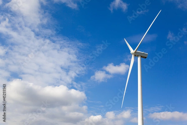 Fototapeta White wind turbine generating electricity on cloudy sky