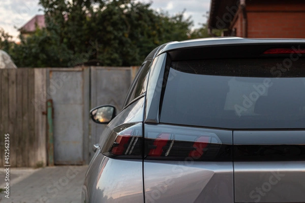 Fototapeta Back window of grey car parked on the street in summer sunny day, rear view. Mock-up for sticker or decals