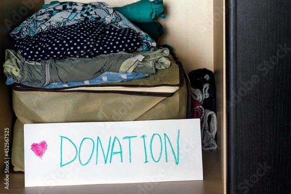 Fototapeta Collecting unnecessary clothes for giving them to charitable organizations to help those in need. Eco-friendly way to get rid of unnecessary things. Concept  donations box, recycle clothes.