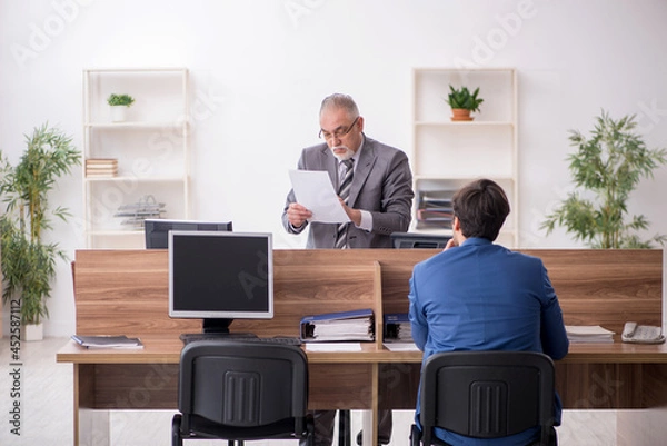 Fototapeta Two male employees working in the office