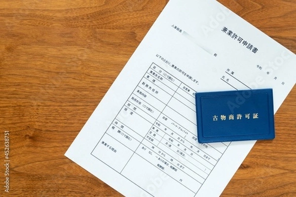 Obraz 会社の人事部長宛てに作成する兼業許可申請書と副業でビジネスをするために取得した古物商許可書（右）