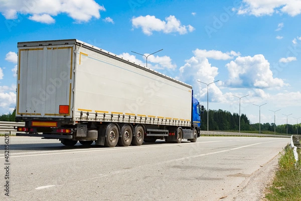 Fototapeta A heavy-duty vehicle with a semitrailer drives along the highway on a summer day.