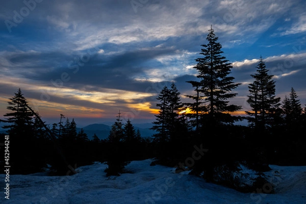 Obraz 春の雲が広がりまだ雪が残る峠道に朝陽が昇る