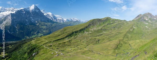 Fototapeta vue panoramique sur des montagnes vertes couvertes d'alpages avec une chaine montagneuse en arrière plan