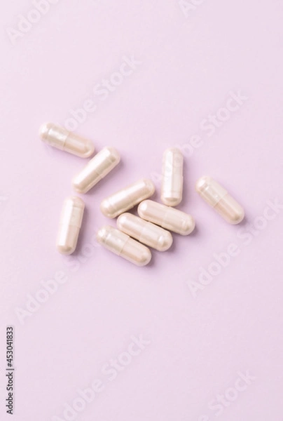 Fototapeta Carnitine capsules. Concept for a healthy dietary supplementation. Bright paper background. Top view. 