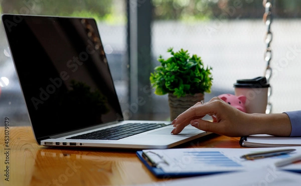 Fototapeta Close up of woman working on project for analyzing company financial report balance statement with documents graphics at modern office. business,economy, market,money and tax concept .