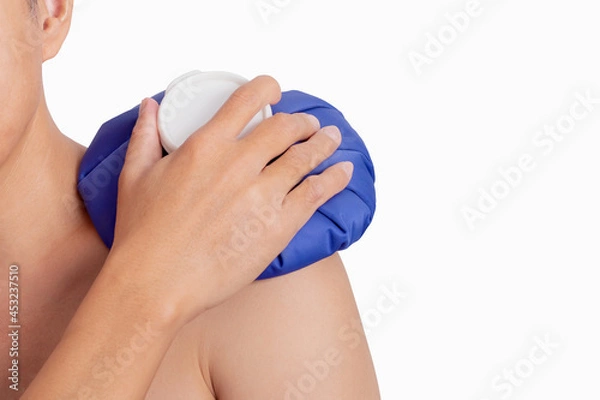 Obraz Man hand holding ice pack bag compress to the shoulder. Reduce pain and swelling