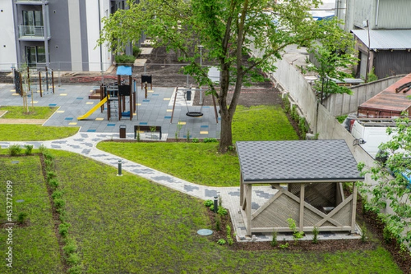Fototapeta The courtyard of modern new residential building with playground.