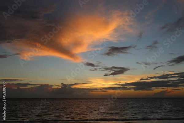 Fototapeta Beautiful yellow sunset over the ocean and different color sky