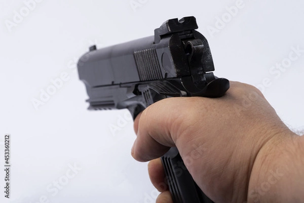 Fototapeta A man's hand shoots a pistol. Pistol on white isolated background. 