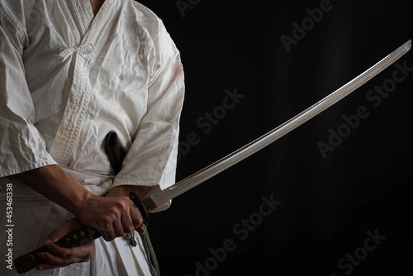 Fototapeta 黒い背景と日本刀を構える人物
