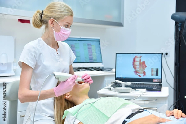 Obraz Ortodontyk skanujący pacjenta za pomocą skanera wewnątrzustnego dentystycznego