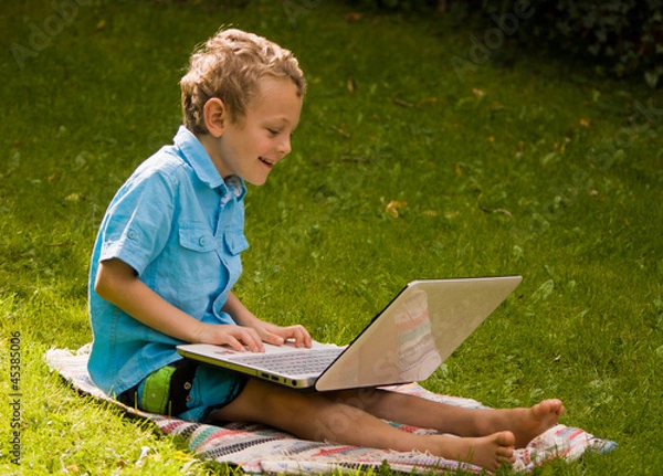 Obraz young boy using his laptop