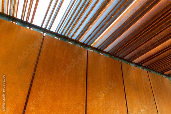 Fototapeta Rust-coated sheet metal forming an abstract image, corten panel and louvers