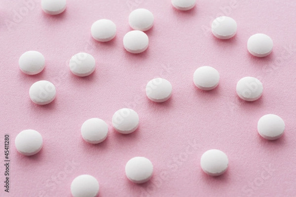 Fototapeta ピンク色の背景に複数の錠剤