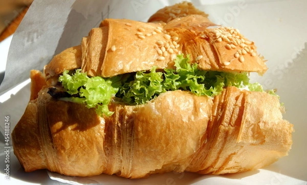 Obraz half a croissant topped with sesame seeds full of green cabbage close-up