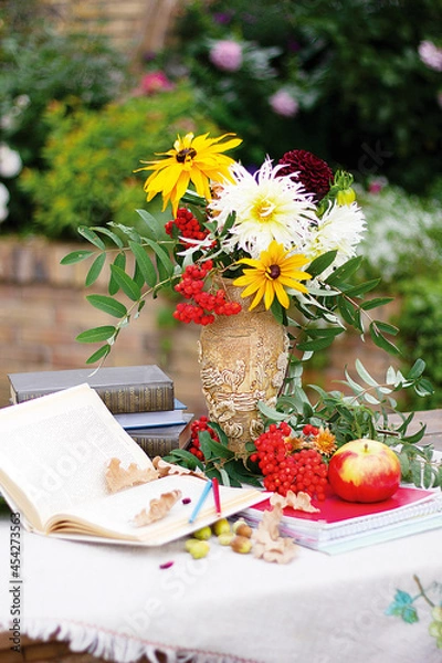 Obraz Autumn flowers with book and ashberry. Still-life with apple and flowers.
