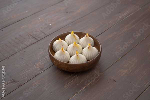 Fototapeta Steamed Modak, ukdiche modak, white modak made from rice flour and coconut jaggery filling. Modak is a traditional Indian sweet made during Ganesh Utsav and also offered to Lord Ganesha.