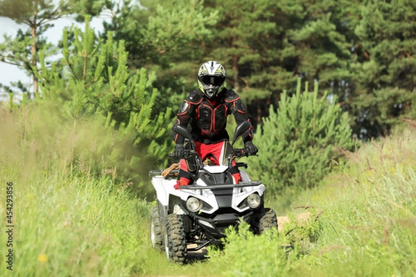 Fototapeta Man driving modern quad bike on road near forest. Extreme sport