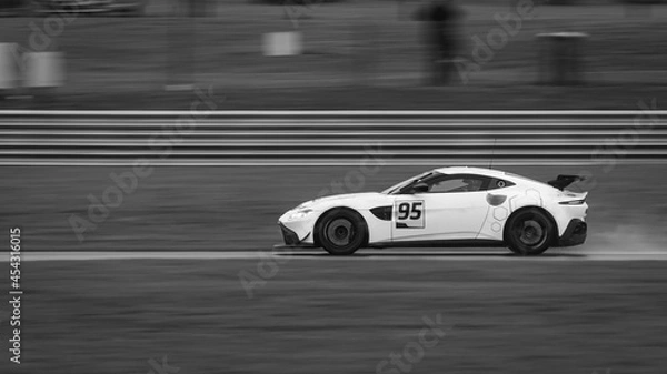 Fototapeta A panning shot of a racing car as it circuits a track.