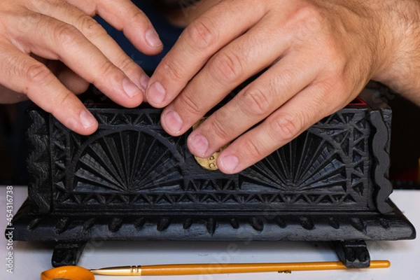 Fototapeta Close-up of a man fixing a wooden box. Concept carpentry at home, furniture restoration