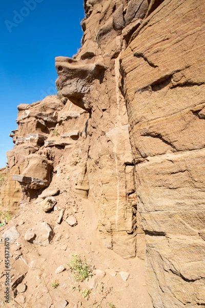 Fototapeta steep ravine slope, sandstone polished by wind and water erosion, stone texture