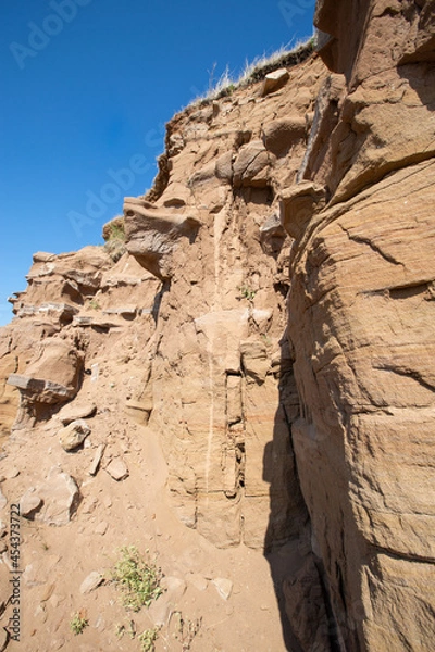Fototapeta steep ravine slope, sandstone polished by wind and water erosion, stone texture