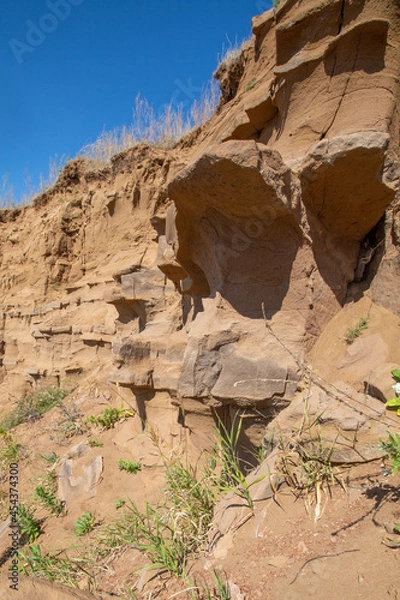 Fototapeta steep ravine slope, sandstone polished by wind and water erosion, stone texture