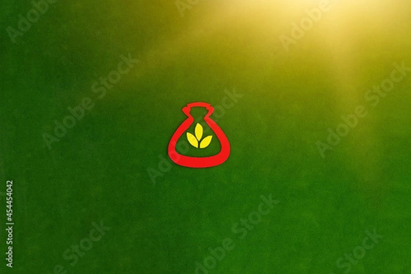 Fototapeta The bag is red, three yellow leaves, meaning gold on a green background. The concept of Financial savings. Investment of funds.