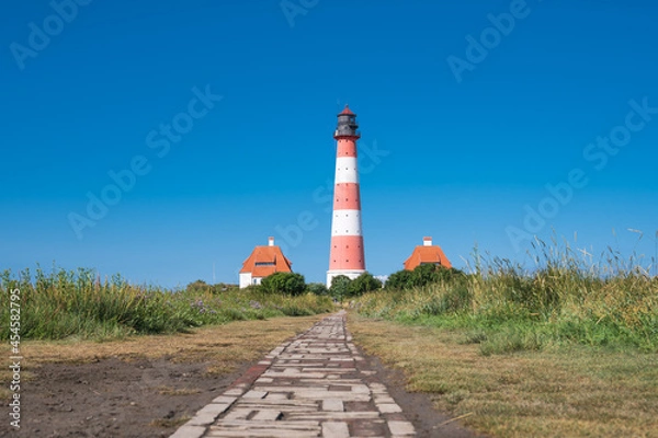 Fototapeta Wanderer nutzen gern den Wanderweg durch das Vogelschutzgebiet beim Westerhever Leuchtturm