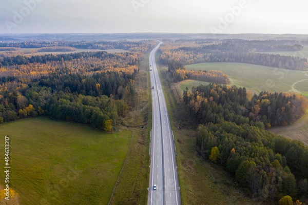 Fototapeta Aerial view of freeway road in autumn forest.