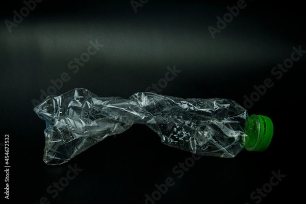 Fototapeta twisted plastic bottle isolated on black background