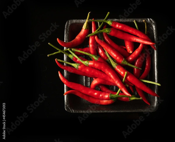 Obraz Chili red peppers in square black box on black background