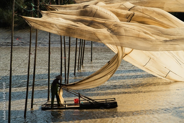 Obraz A fisherman hangs giant fishing nets to dry in Xiapu, China's Fujian province