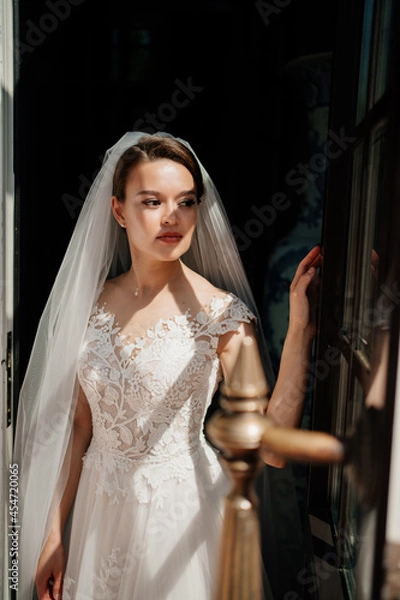 Fototapeta a beautiful and gentle bride in a dark room by the window. 