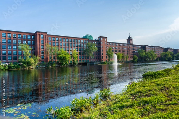 Obraz A heritage cotton mill building with a clock tower in the old industrial park of Nashua. Nashua Corporation. Nashua Manufacturing Company, New Hampshire, USA
