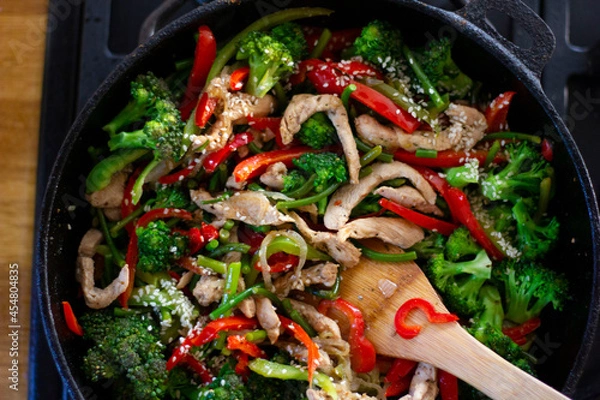 Obraz Coocing vegetables in a frying pan. Broccoli, carrots, string beans on cast iron frying pan. Vegetarian Food.
