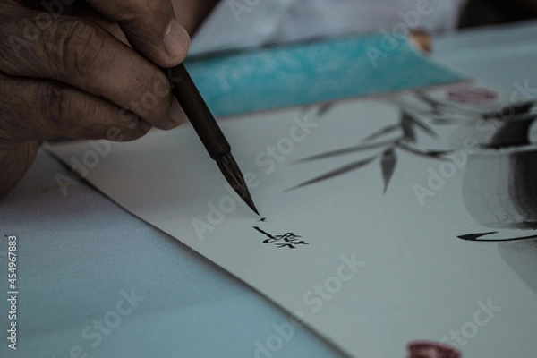 Fototapeta mano de un japonés escribiendo letras chinas con tinta