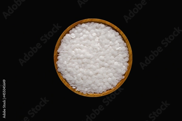 Fototapeta Wax resin on wooden plate. Beads wax pellets background. wax pallet isolated on black background. pe wax. lubricate wax.