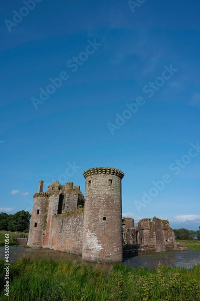 Fototapeta Vertical orientation of Caerlaverock Castle, Dumfries and Galloway, Scotland, in sunshine with blue sky, no people. Lots of copy space above in sky area.