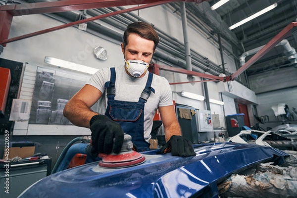Fototapeta Pozytywny technik motoryzacyjny szlifowanie części motoryzacyjnej części ciała