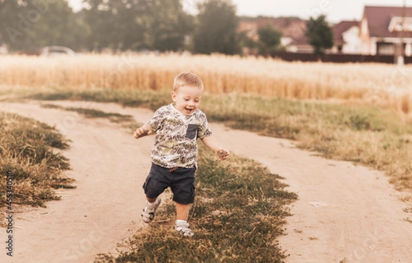 Obraz Little boy running down a rural road in summer
